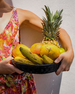 Midsection of woman holding fruit basket