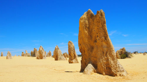 Panoramic view of desert against blue sky