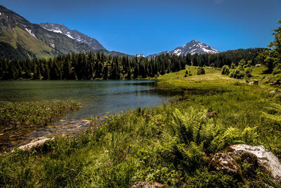 Scenic view of lake and mountains against clear sky