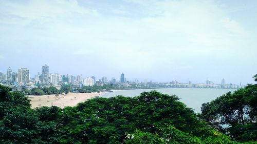 Panoramic view of buildings and trees against sky