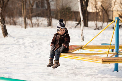 Full length of boy on snow covered landscape during winter