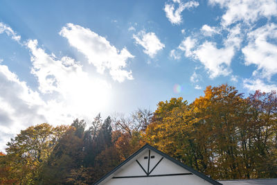 Low angle view of trees and building against sky