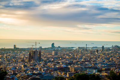 High angle view of buildings in city against cloudy sky