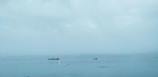 Sailboats in sea against sky