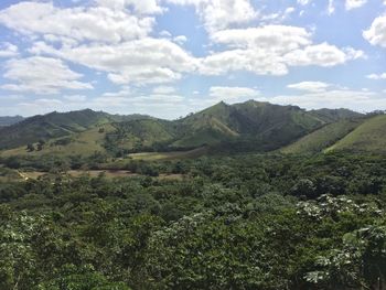 Scenic view of green landscape and mountains against sky