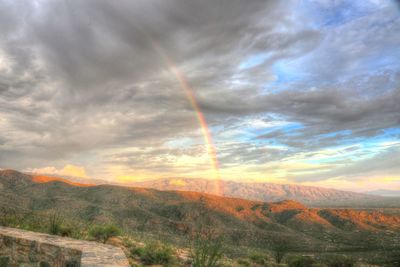 Scenic view of rainbow over landscape against sky