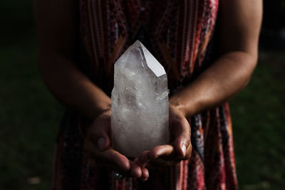 Midsection of woman holding rock