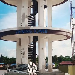 Low angle view of sign against sky in city