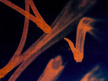 Close-up of graffiti on metal structure at night