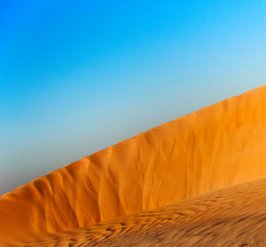 Scenic view of desert against clear blue sky