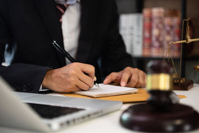 Midsection of man holding paper at table