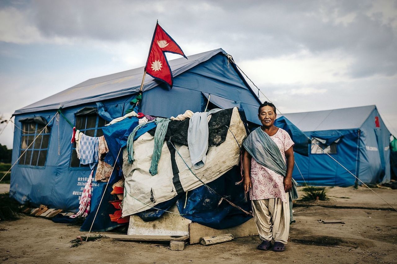 sky, cloud - sky, abandoned, cloud, built structure, sand, building exterior, flag, clothing, beach, architecture, day, cloudy, tent, outdoors, drying, graffiti, multi colored, house, damaged