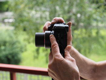 Midsection of man photographing camera