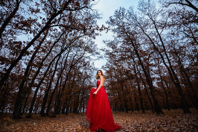 Full length of woman standing in forest