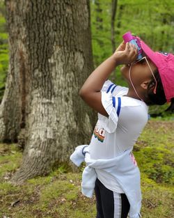 Side view of child standing in woods