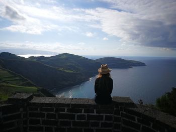 Rear view of woman looking at sea against sky