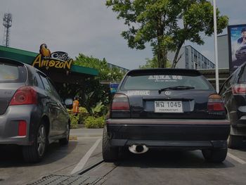 Cars on street in city against sky