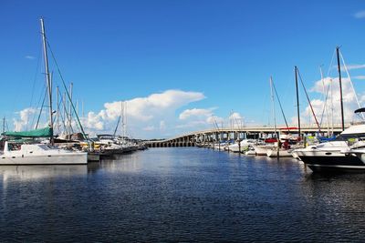 Boats moored at harbor against sky