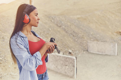 Woman releasing stress, instructor helping woman with gun