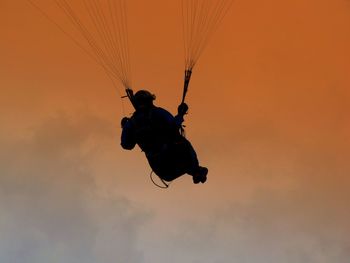 Rear view of parachuting against the sky