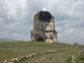 Old ruin building on field against sky
