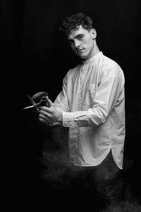 Side view of young man holding plant