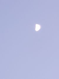 Low angle view of moon against clear blue sky