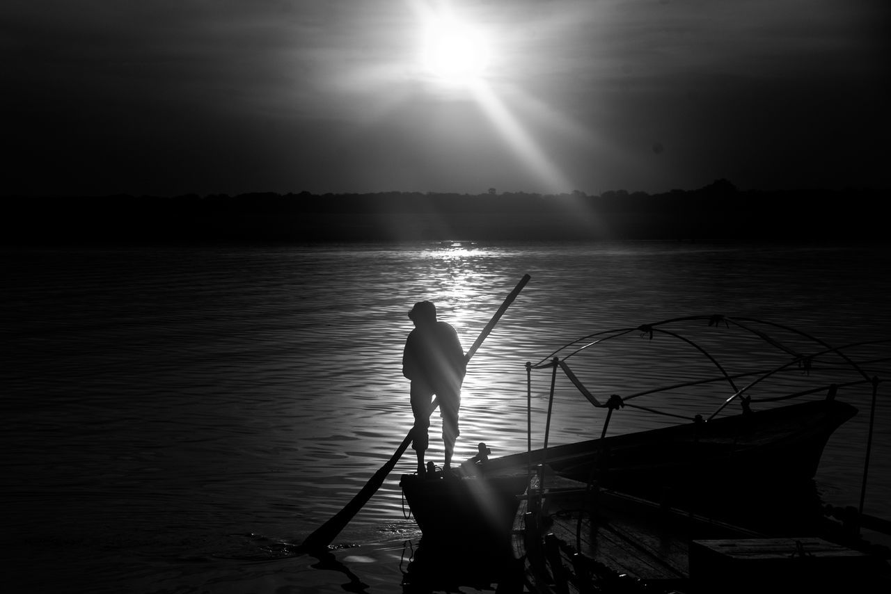 SILHOUETTE OF MAN FISHING IN SEA