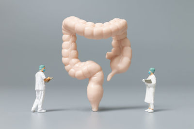 Close-up of figurine on table against white background