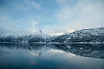 Scenic view of lake by mountains against sky