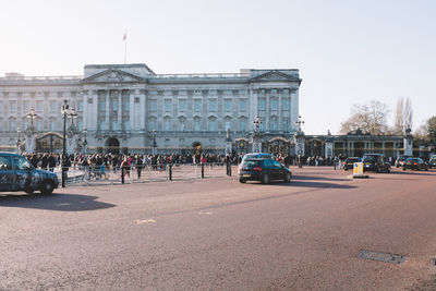 People at buckingham palace against sky