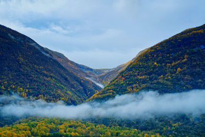 A blanket of fog settles between the colorful mountain peaks and the valley floor