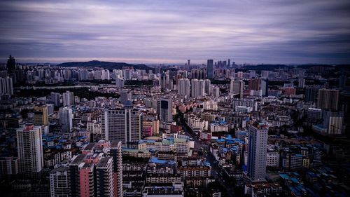 High angle view of city lit up against sky