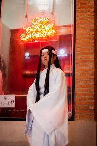 Young woman looking away while standing in restaurant
