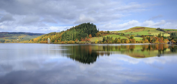 Scenic view of lake by trees against sky