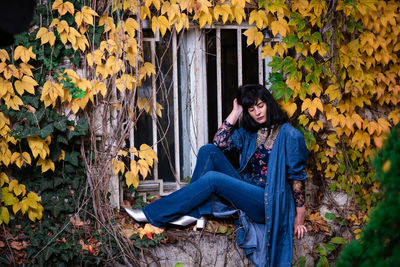 Young woman sitting on autumn leaves