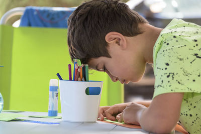 Primary school boy doing manual work while on vacation and preparing to go back to school.