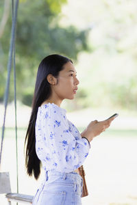 Side view of young woman looking at camera