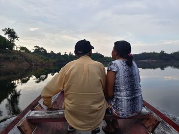 Rear view of couple kissing against sky