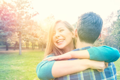 Close-up of embracing while standing on field at park