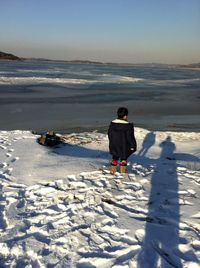 Full length rear view of man on beach during winter