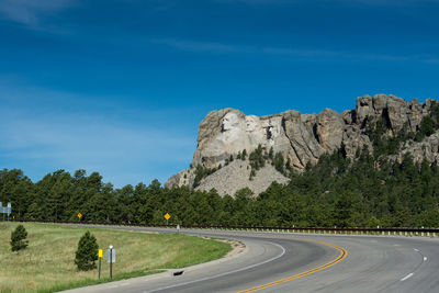 Road by mountain against blue sky