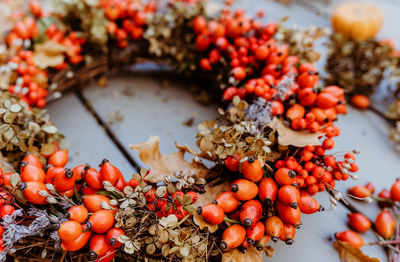 Handmade colorful floral autumn door wreath made of colorful rosehip berries, rowan, dry flowers 