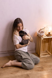 Young woman using mobile phone while sitting at home