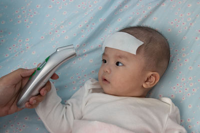 Portrait of cute baby girl lying on bed