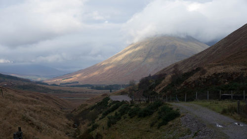 Scenic view of mountains against cloudy sky