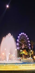 Illuminated ferris wheel at night