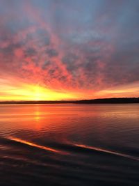 Scenic view of sea against dramatic sky during sunset
