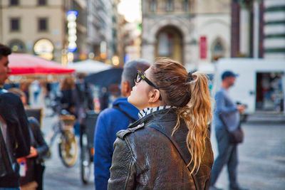 Young woman standing on street in city