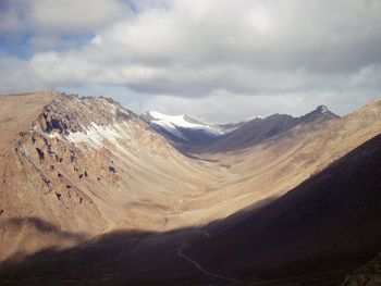 Scenic view of mountains against cloudy sky